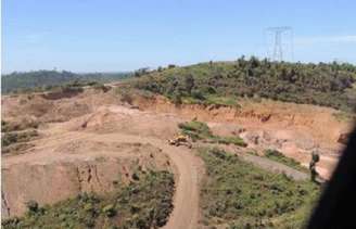 Área próxima da base de torre de transmissão de energia com sinais de atividade de garimpo.