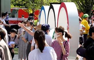 Pessoas posam ao lado dos anéis olímpicos, em frente ao Estádio Olímpico, o principal estádio dos Jogos Olímpicos e Paralímpicos de Tóquio 2020, no Japão
23/07/2021 REUTERS/Fabrizio Bensch