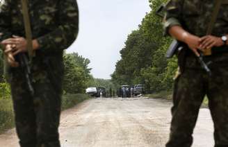 <p>Soldados ucranianos protegem área onde rebeldes pró-russos mataramcerca de 18 militares militares ucranianos na periferia da cidade ucraniana de Volnovakha, ao sul de Donetsk, em 22 de maio</p>