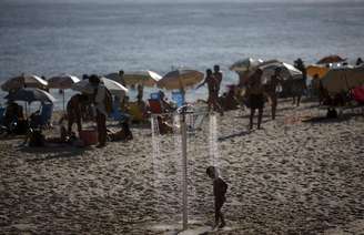 <p>Menino se refresca em chuveiro na praia do Arpoador, no Rio de Janeiro.</p>