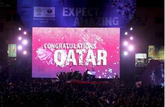 Pessoas comemoram a escolha do Catar para sediar a Copa de 2022, em Doha.  02/12/2010
