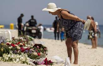 Turista lê mensagens deixadas num memorial na praia perto do hotel Imperial Marhaba, alvo do ataque de um atirador, em Sousse, na Tunísia. 29/06/2015