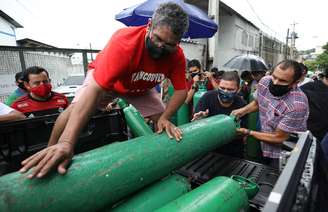 Parentes de pessoas doentes tentam recarregar cilindros de oxigênio em empresa privada em Manaus (AM) 15/01/2021 REUTERS/Bruno Kelly