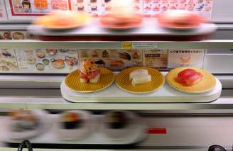 Balcões com três decks de raias de alta velocidade fornecem sushi diretamente à pessoa que fez o pedido em uma tela sensível ao toque multilínguas