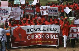 <p>Manifestantes do grupo "trabam de volta nossas garotas" (Bring Back Our Girls) marcham para a vila presidencial para entregar uma carta de protesto ao presidente da Nigéria em Abuja, pedindo a libertação das estudantes sequestradas em Chibok pelo grupo islâmico Boko Haram</p>