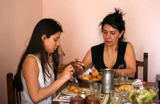 Silvia Gauna e sua filha, Maia, almoçam na casa em que moram em Buenos Aires
26/09/2019 REUTERS/Agustin Marcarian 