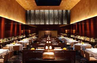 Mesas de mogno, talheres de prata e louça com o logotipo do restaurante mais sofisticado do Brasil: bem-vindo ao Fasano