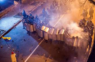 Manifestante agita bandeira ucraniana durante confrontos na capital Kiev