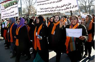 <p>Mulheres afegãs entoam slogans durante manifestação para protestar contra a violência contra o novo projeto de lei que limita a justiça à vítimas de violência doméstica, em Cabul, em 13 de fevereiro</p>