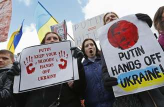 <p>Pessoas se manifestando contra as tropas russas na Ucrânia do lado de fora de uma reunião emergencial entre ministros das Relações Exteriores da União Europeia em Bruxelas</p>