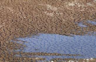 <p>Poça vista no chão rachado na represa de Jaguari em Bragança Paulista; nível de água do Sistema Cantareira está em 12% de sua capacidade</p>