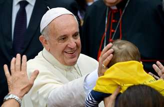 <p>Papa Francisco acaricia cabeça de bebê em sua chegada na Basílica de Santa Maria de Trastevere em Roma</p>