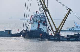 Equipes de resgate se aproximam dos destroços do barco rebocador que naufragou no rio Yangtze, na China