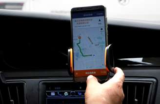 Motorista da Didi Chuxing verifica as informações no aplicativo em seu carro em Pequim 28/08/018. REUTERS/Jason Lee 