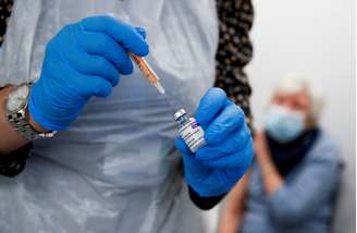 Um profissional de saúde enche uma seringa com uma dose da vacina Oxford / AstraZeneca COVID-19