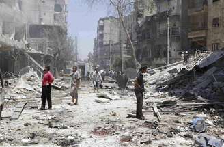 Sírios inspecionam um local atingido pelo o que ativistas dizem ter sido uma bomba lançada por forças leais ao presidente sírio, Bashar al-Assad, em Aleppo, na Síria, na segunda-feira. 16/06/2014