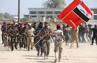 <p>Voluntários xiitas do Hezbollah marcham ao se juntarem ao exército iraquiano, para combater os militantes jihadistas do Estado Islâmico (EI), anteriormente conhecido como o Estado Islâmico do Iraque e do Levante (EIIL), nesta quarta-feira, 9 de julho, em Bagdá</p>