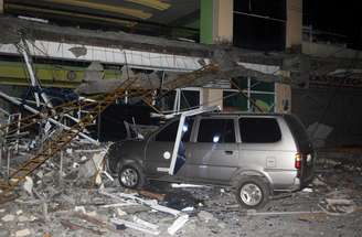 Carro é atingido por escombros de prédio durante terremoto no sul das Filipinas.