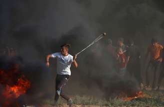 Manifestante palestino arremessa pedras contra tropas israelenses em Gaza
17/08/2018 REUTERS/Mohammed Salem