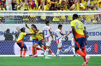  Colombianos comemoram o gol de Muñoz (centro, sendo celebrado pelos companheiros) o primeiro no duelo contra o Paraguai  –