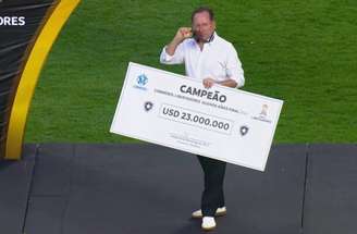 Reprodução de TV - Legenda: John Textor com o cheque da premiação pela conquista da Libertadores