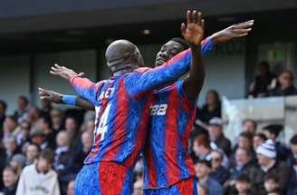 Justin Setterfield/Getty Images - Legenda: Sarr, de frente, é celebrado por Mateta logo aós fazer o segundo gol do Crystal Palace sobre Fulham