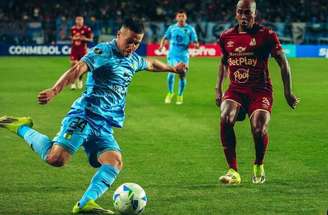 Jersson González (de vinho) domina a bola para o Tolima e Brizuela, do O’Higgins corre para fazer a marcação