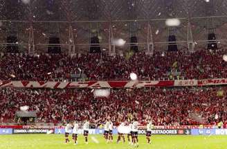 Funcionários fazem a limpeza do gramado do Beira-Rio enquanto jogadores aquecem –