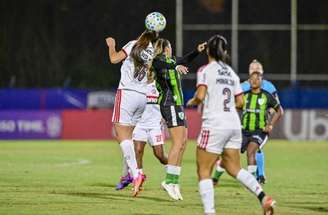 Djeni (de branco, do Flamengo) tenta evitar o ataque do América.