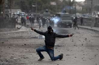 Egipcio faz sinal de vitória em meio aos confrontos com policiais nas imdeiações da Praça Tahrir