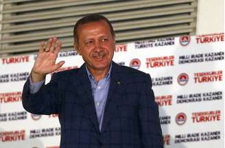 <p>Tayyip Erdogan acena para simpatizantes durante a celebração de sua vitória na corrida presidencial em Ancara, em 10 de agosto</p>