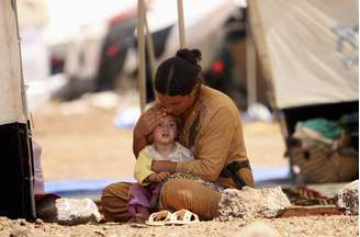 Mulher e criança da minoria yazidi, do Iraque, se refugiam em campo na Síria