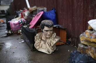 Busto de Elvis Presley  é deixado na calçada com destroços resultantes da passagem do furacão Sandy no bairro de Midland Beach, em Staten Island, na cidade de Nova York. 13/11/2012