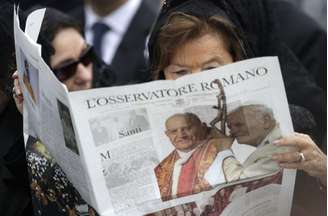 Mulher lê o periódico do Vaticano, "L'Osservatore Romano", na Praça de São Pedro 
27/04/2014
REUTERS/Max Rossi