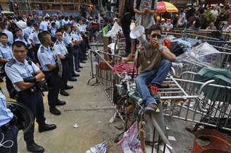 <p>Um manifestante tenta impedir taxistas de removerem barricadas montadas em uma área ocupada no bairro de Mong Kok, em Hong Kong, em 22 de outubro</p>