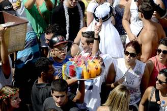 Vendedor serve bebidas em desfile de blocos