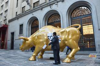 Escultura do Touro de Ouro teve cartazes contra a fome colado por manifestantes