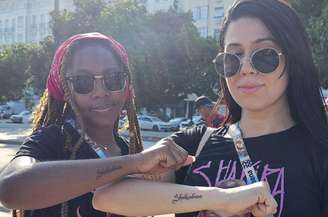Kariny Gomes (à esq.) e Rayana de Souza (à dir.) tatuaram ‘Shakiracabana’ no braço