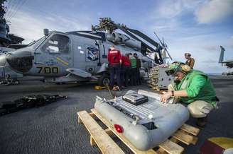 Equipe remove equipamentos do porta-aviões para dar lugar a suprimentos e pessoal enviados às Filipinas