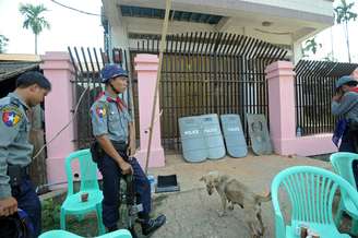 <p>Polícia de Mianmar fica de guarda na frente do escritório destruído de uma ONG, em Sittwe, estado Rakhine, Myanmar, em 28 de março</p>