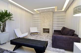 Neste apartamento de 225m² no Jardim Anália Franco, em São Paulo, a arquiteta Érica Salguero fez uma sala em que predominam tons neutros. Ganham destaque a lareira, emoldurada por um mosaico de mármore, e o sofá arroxeado. Informações: (11) 2093-8658