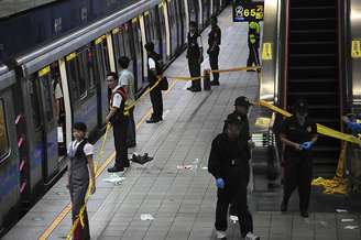 <p>Investigadores caminham na plataforma do metrô de Jiangzicui, onde um homem atacou vários passageiros com uma faca</p>