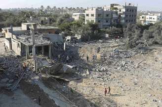 <p>Palestinos observam casa destruída por ataque aéreo israelense na Faixa de Gaza</p>