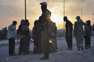 <p>Membros do Estado Islâmico fazem guarda em um ponto de inspeção em Mossul, no norte do Iraque</p>