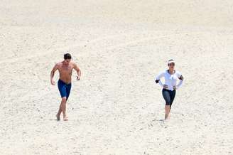 Cléo Pires e Rômulo Neto caminham na praia