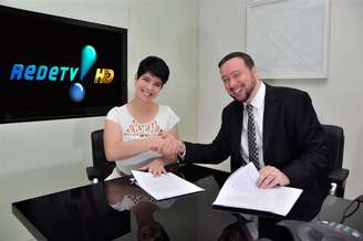 <p>Mariana Godoy assina contrato ao lado do superintendente de Jornalismo e Esportes da RedeTV!, Franz Vacek</p>