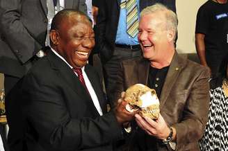 Lee Burger, professor da Universidade de Witwatersrand, e o vice-presidente da África do Sul posam com o crânio descoberto