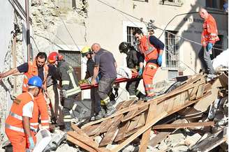 Ferido por terremoto é levado por equipe de socorro na Itália