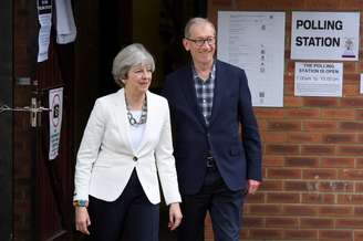 Theresa May vota no Reino Unido acompanhada do marido