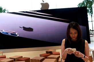 Mulher verifica seu telefone em uma  loja da Apple em shopping center de Bancoc 9/11/ 2018. REUTERS/Soe Zeya Tun 